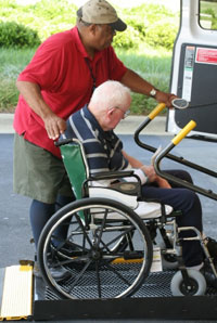 Volunteer Helping Transport Man in Wheelchair